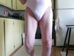 Sissy bitch poses in a pink, spandex woman's leotard.